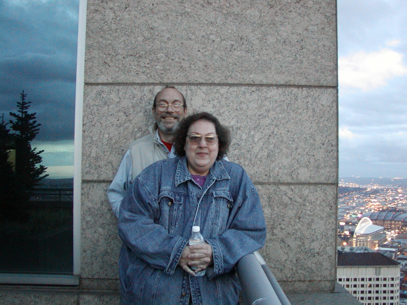 Woman and Man on the outdoor balcony of a tall building in Seattle.