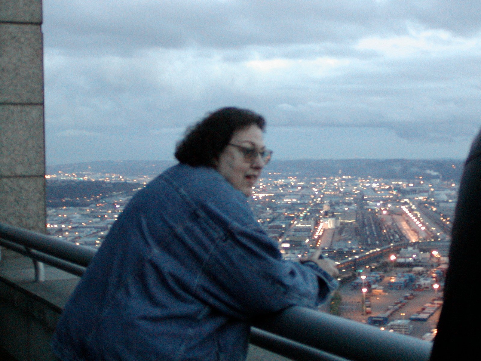 Woman on the outdoor balcony of a tall building in Seattle.