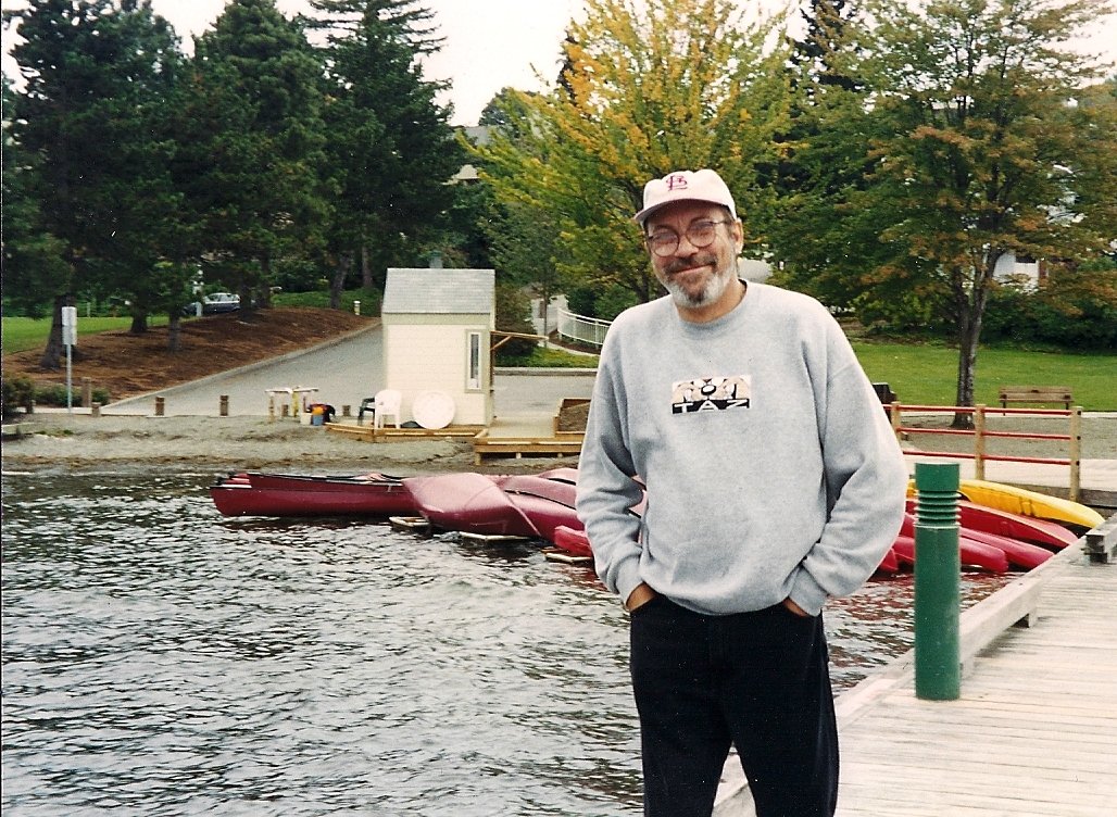 Thin man in ball cap and gray sweatshirt.